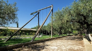 A park with a swing set, a paved path, and a grassy area with trees.