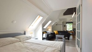 A bedroom with a large bed, a desk, and a chair, with a view of a dining area and a window. - Modern Holiday Home in Wolphaartsdijk with Private Garden (Wolphaartsdijk)