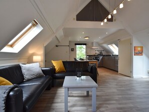 Een ruime loftappartement met een eethoek, keuken en een groot raam dat zorgt voor daglicht.