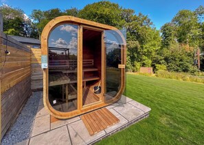 A wooden sauna with a glass door, a bench inside, and a small step leading up to it. - Spa Utopia (Sauna & Hot tub) (Raywell, Beverley)