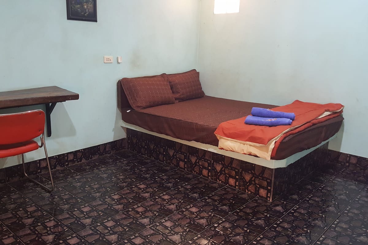 A small room with a bed, a desk, and a chair.