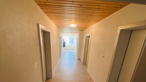 A hallway with wooden ceiling and light-colored walls, leading to a bright room at the end. - Apartment in Salchau near Lachtal Ski Area (Salchau)