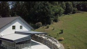 A house with a sloped roof, a glass conservatory, and a stone wall. - Apartment in Salchau near Lachtal Ski Area (Salchau)
