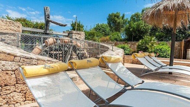 A pool area with lounge chairs and a stone wall. - Villa with private pool in a privileged environment. Wifi, A/c & lovely BBQ (Alcúdia)
