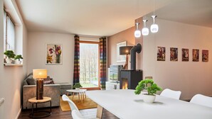Ein modernes Wohnzimmer mit Kamin, Esstisch und Sofa.