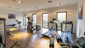Ein Fitnessstudio mit Laufbändern, Crosstrainern und Gewichten.