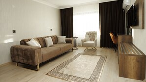 Un salon moderne avec un canapé, un fauteuil et une table basse en bois.