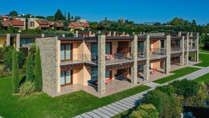 Un hôtel à plusieurs étages doté de balcons, d’un espace extérieur aménagé et d’un jardin paysager.