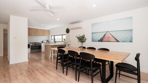 A modern kitchen with wooden cabinets, a built-in oven, and a central island with seating. - Stratford by the Sea in Rye (Rye)