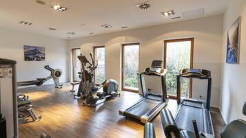 Ein Fitnessstudio mit Laufbändern, Crosstrainern und Gewichten.