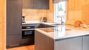 Een moderne keuken met houten wanden, een groot schiereiland met een spoelbak en geïntegreerde apparaten.