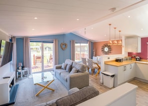 A modern living room with a sofa, coffee table, and dining area.