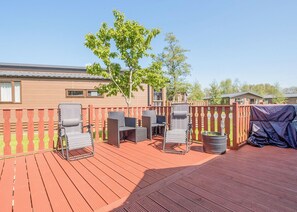 A deck with outdoor furniture, a tree, and a covered area. - 3 bedroom accommodation in Carnforth (Carnforth)