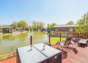 A riverside view with outdoor seating, a pond, and row houses.