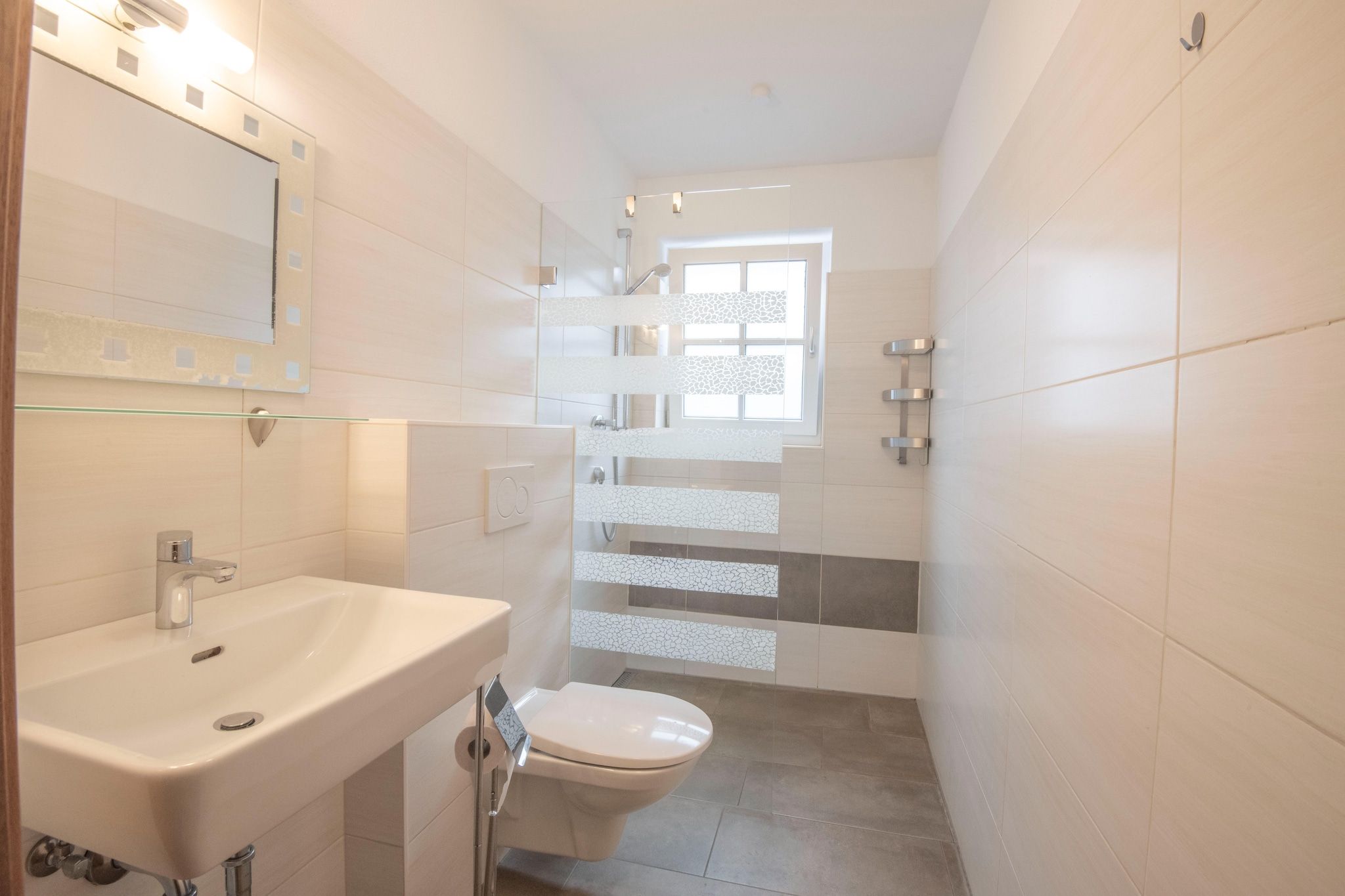 Ein modernes Badezimmer mit Waschbecken, Toilette und Duschbereich.