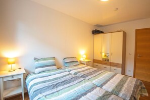 A bedroom with a bed, bedside tables, a wardrobe, and a door. - Modern Apartment in Brixen im Thale near Ski Area (Brixen im Thale)
