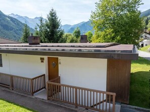 A small building with a flat roof, a wooden door, and a small balcony.