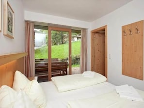 Une chambre à coucher avec un lit, un banc et une porte en bois.