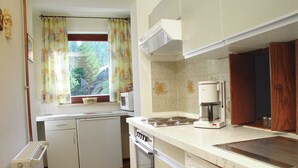 Una cocina compacta equipada con lavavajillas, estufa y cafetera.