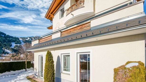 A two-story building with a balcony, large windows, and a view of a snowy landscape. - Inviting Apartment in Fiss in the Mountains (Fiss)