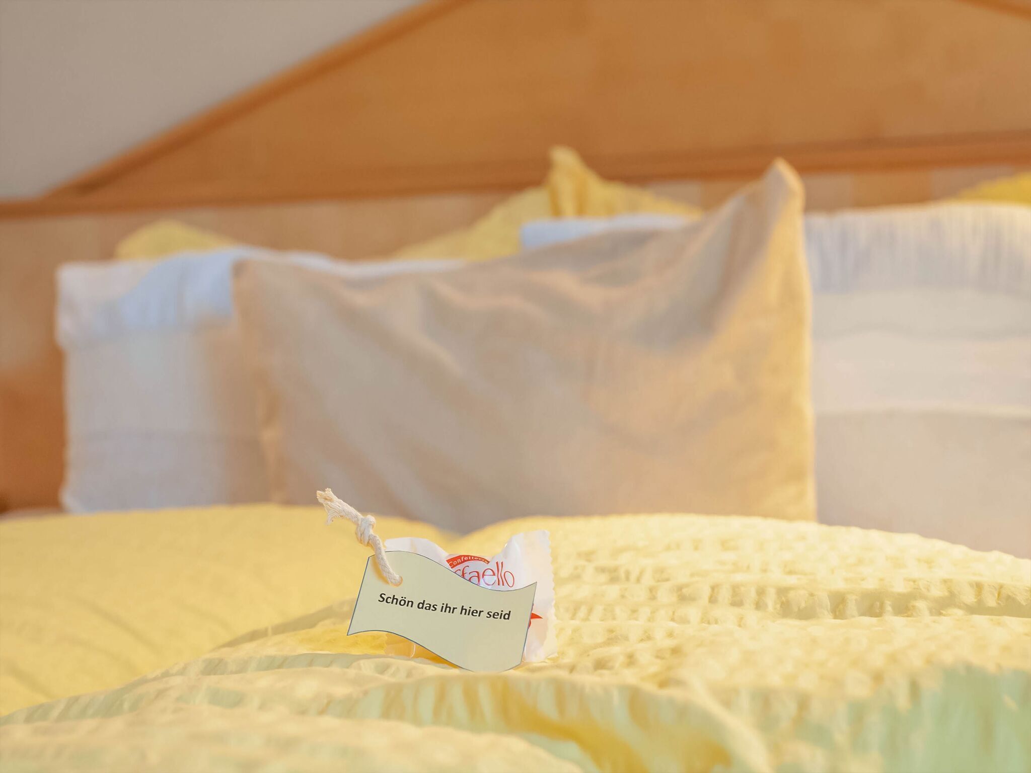 Ein ordentlich bezogenes Bett mit einem angenähten Etikett auf dem Kopfkissen.