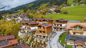 A mountainous village with wooden houses, some with balconies, and a road winding through the area.