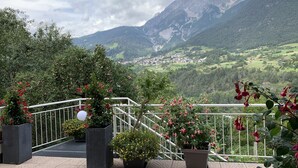 Un balcó amb plantes en testos i vista a un paisatge de muntanya.