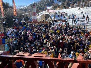 A crowded ski resort with a large gathering of people, ski lifts, and a prominent ski lift tower. - Cozy apartment overlooking a garden in a magnificent panoramic location (Landeck)