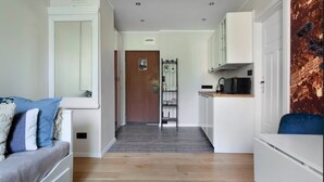 A modern kitchen with white cabinets, a microwave, and a coffee maker.