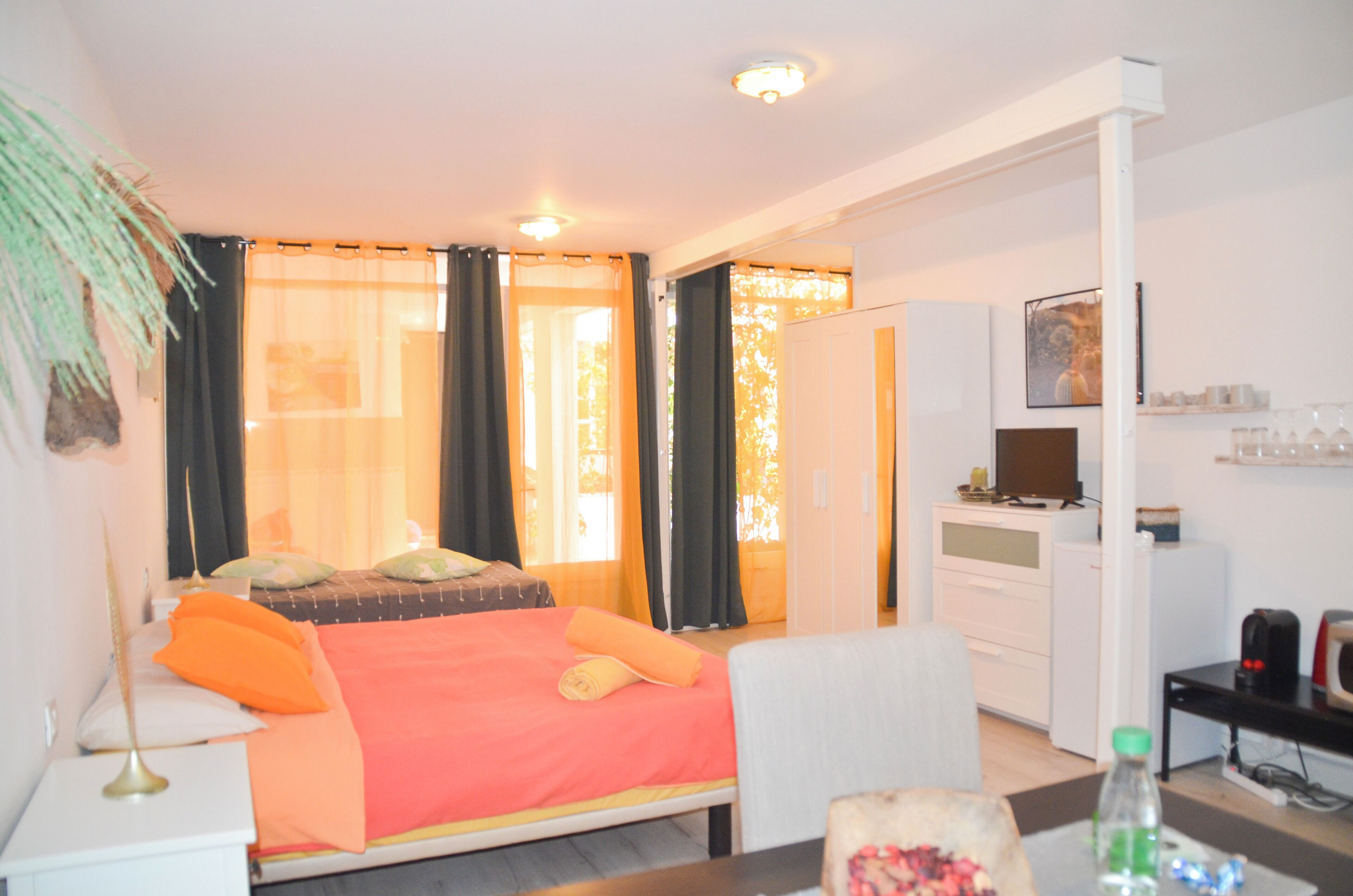 Een hotelkamer met een bed, een bureau, een stoel, een televisie en een minibar.