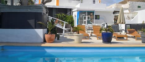 Piscine extérieure, parasols de plage, chaises longues