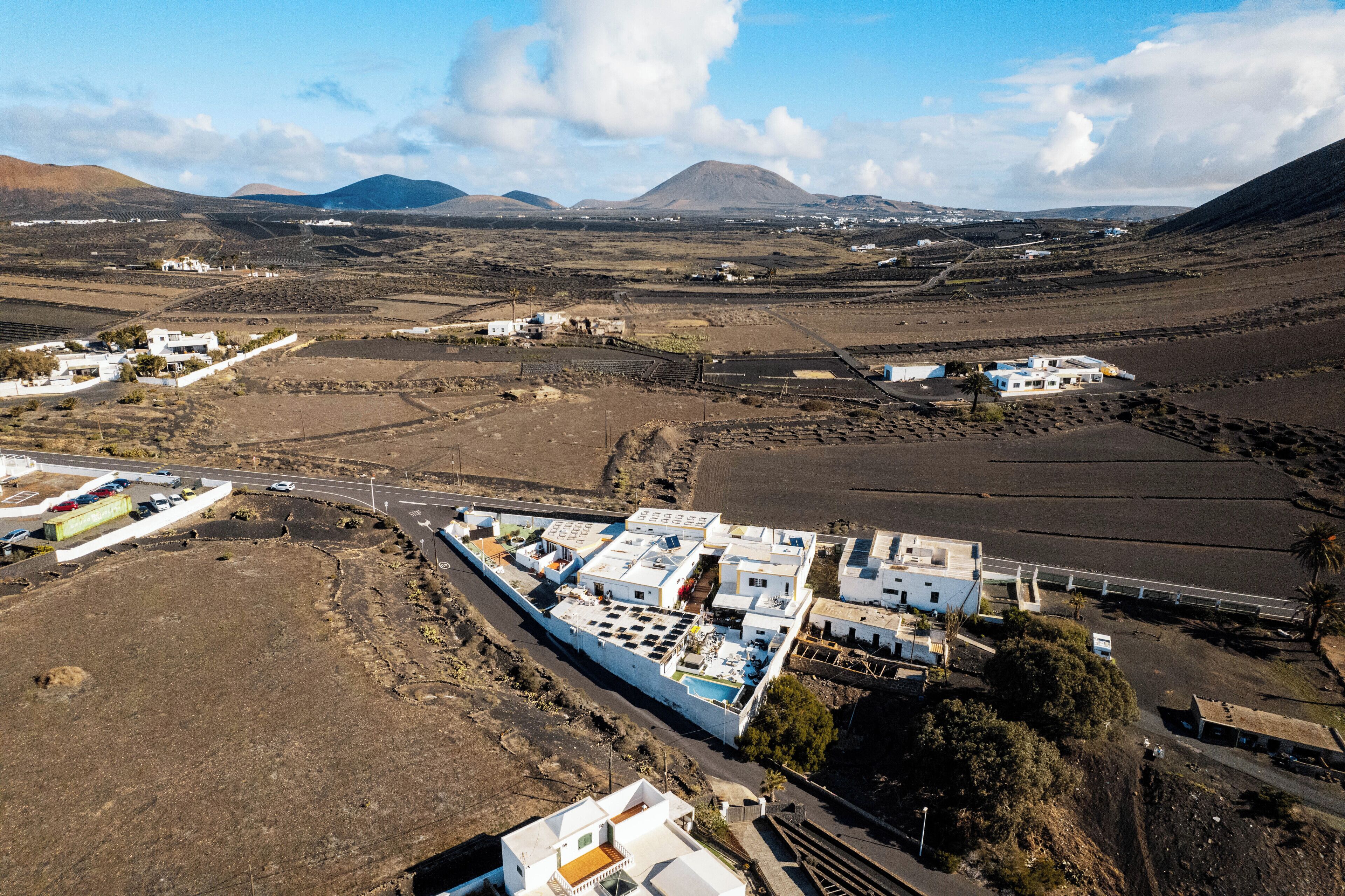 An aerial view of a coastal area with buildings, roads, and fields.
