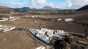 An aerial view of a coastal area with buildings, roads, and fields.