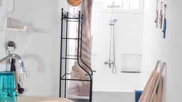 A bathroom with a wooden ceiling, a sink, a bidet, and a shower.