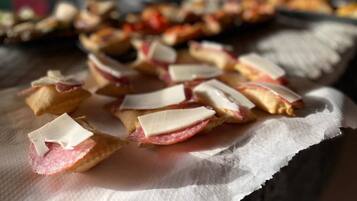 Una mesa con comida, incluyendo sándwiches de queso y jamón, sobre una servilleta.