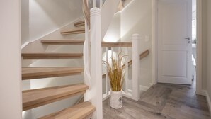 A staircase with wooden steps and white railings, leading to a white door. - House Munkmarscher Straße 14c (Westerland)