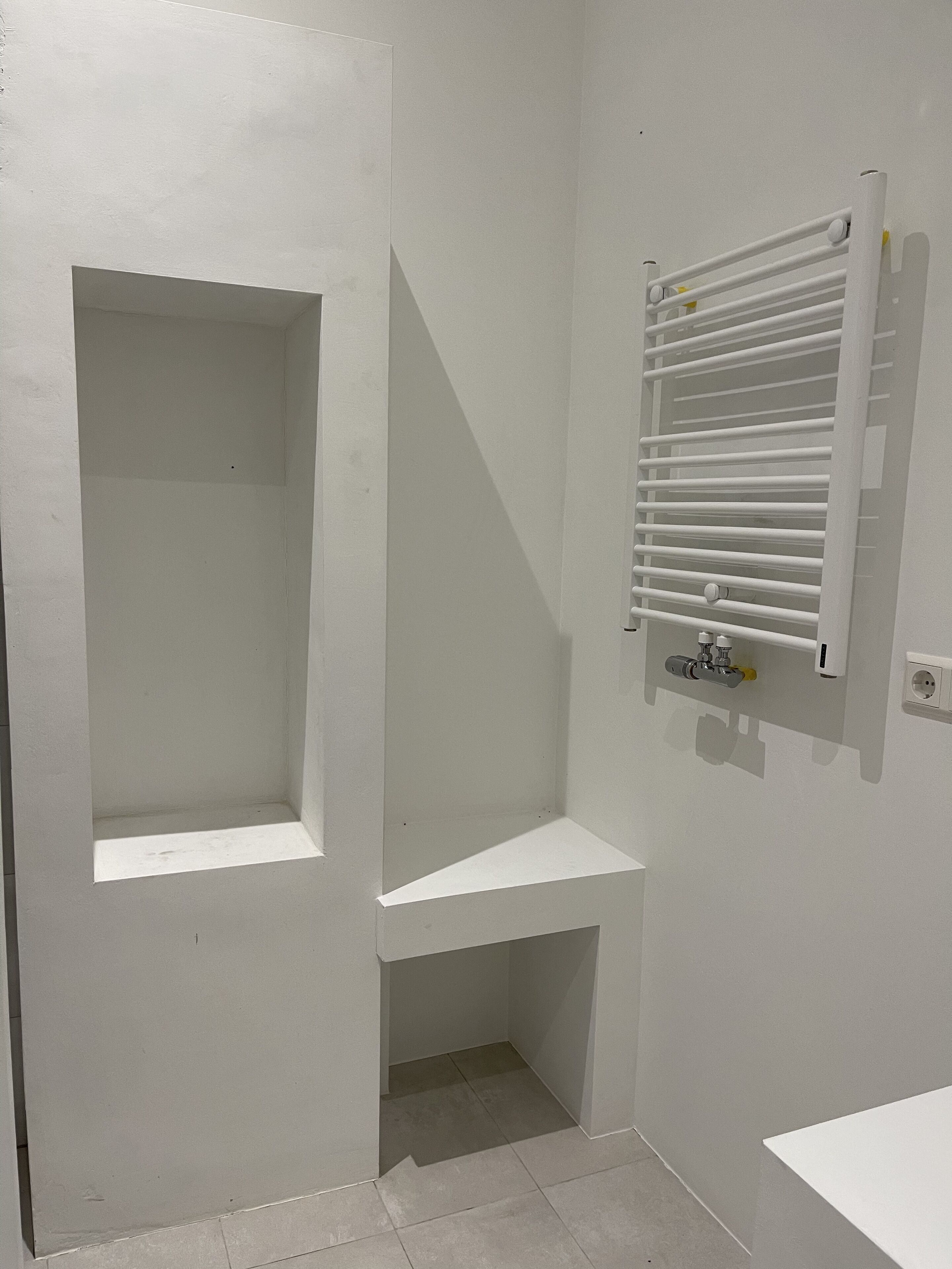 Een badkamer met een douche, een handdoekhouder en een wastafel.