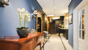 Un pasillo con una consola de madera, un espejo grande y una escalera que lleva a otra habitación.