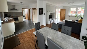 A modern apartment with a kitchen, dining area, and living room. - Beautiful holiday home with hot tub. In short: relax and enjoy! (Neubörger)