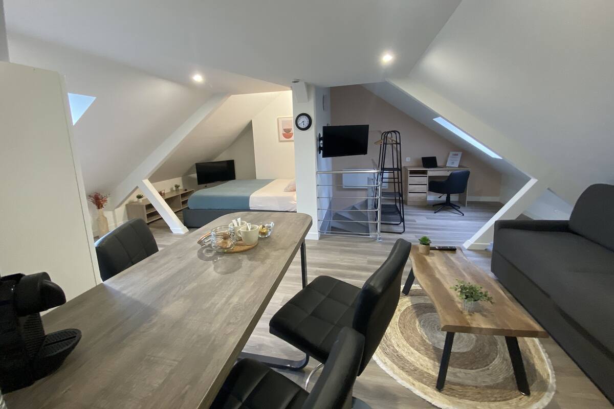 Un moderno apartamento tipo loft con comedor, sala de estar y espacio de trabajo.
