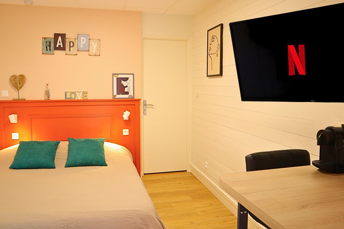 Une chambre d’hôtel avec un lit, une table en bois, une télévision et une porte.