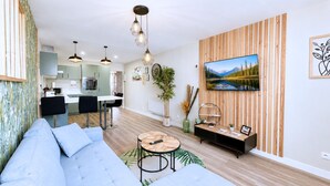Een moderne woonkamer met een bank, een salontafel en een tv die aan een houten wand is bevestigd.