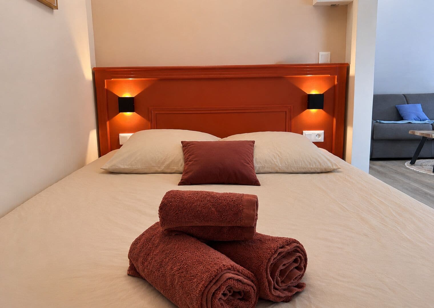 Een hotelkamer met een bed, twee bedlampen, een bank en een kleine tafel.