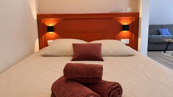 Een hotelkamer met een bed, twee bedlampen, een bank en een kleine tafel.