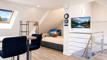 Un dormitorio moderno con cama tipo loft, un escritorio y una silla.