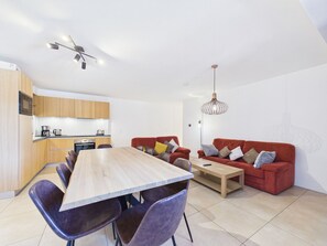 A modern living space with a dining area, kitchen, and seating area.