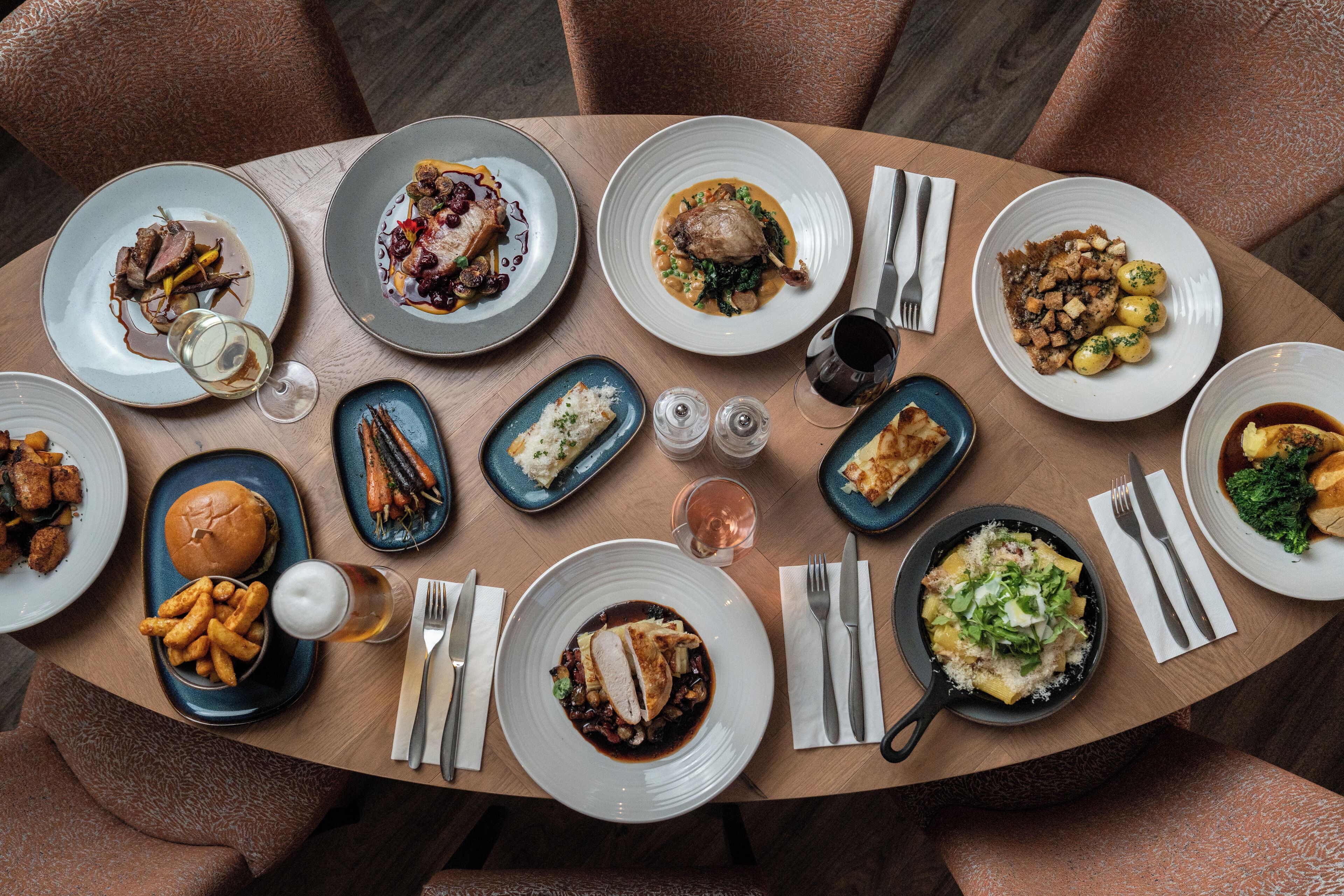 Una mesa de comedor con varios platos y cubiertos.