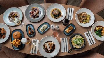 Una mesa de comedor con varios platos y cubiertos.