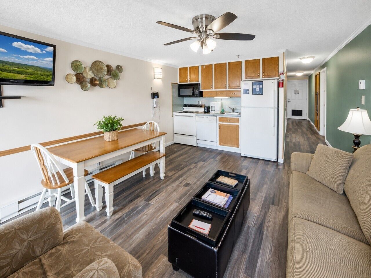 A compact living space with a dining area, kitchenette, and seating area.