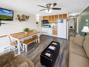 A compact living space with a dining area, kitchenette, and seating area.